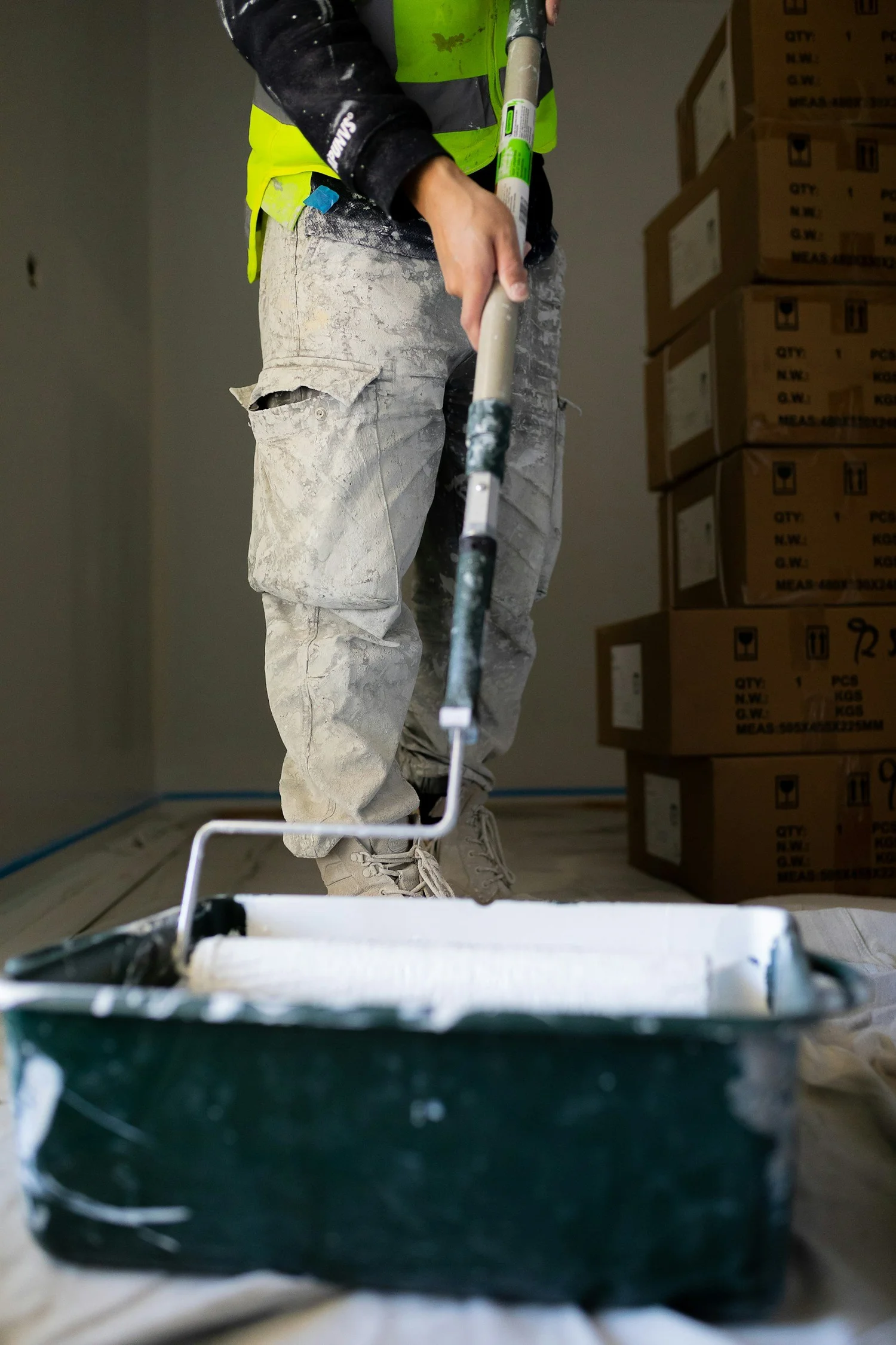 J Barnes Painting crew member rolling paint on a job site